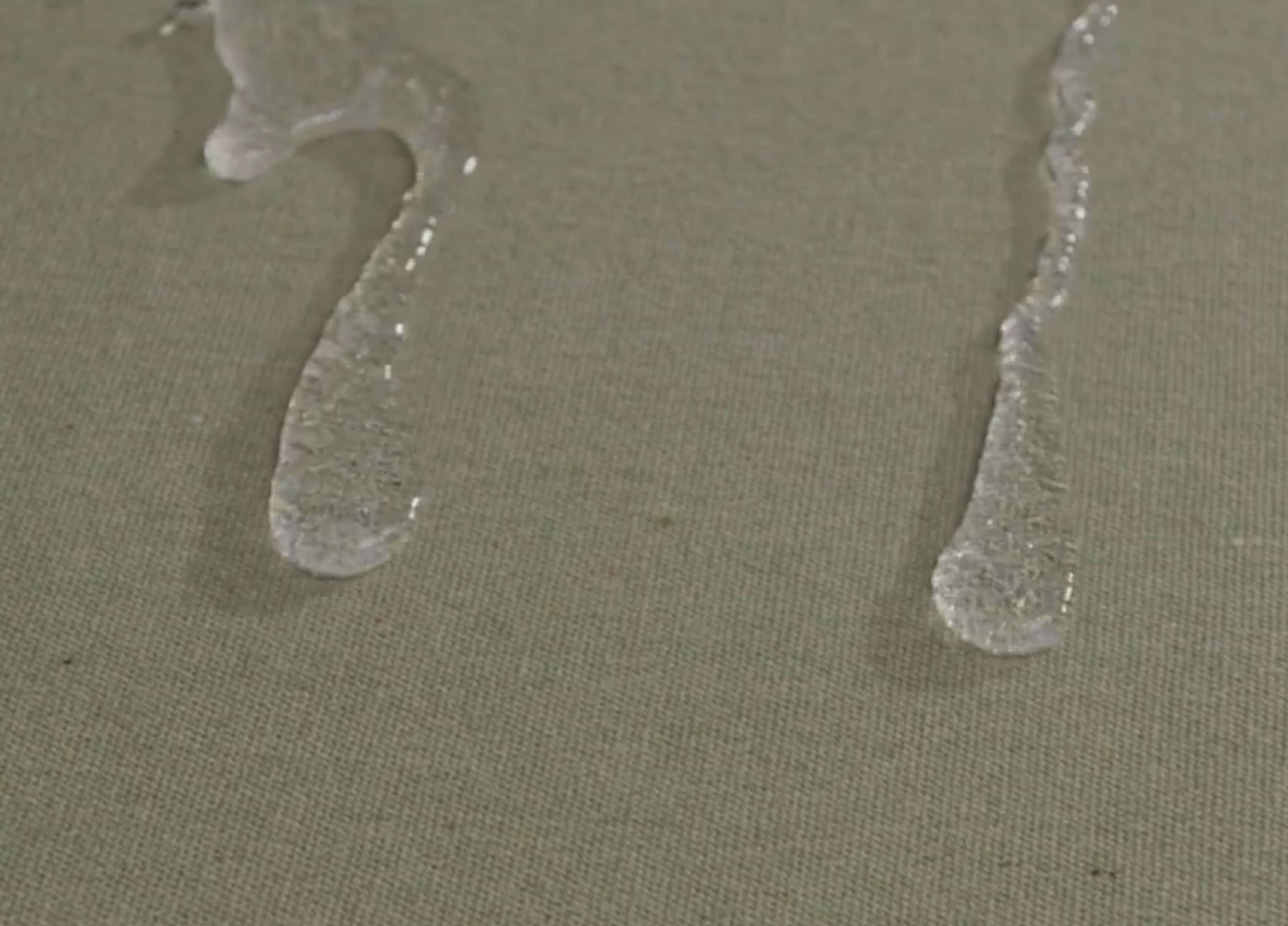 A close up image of sand on the beach and water