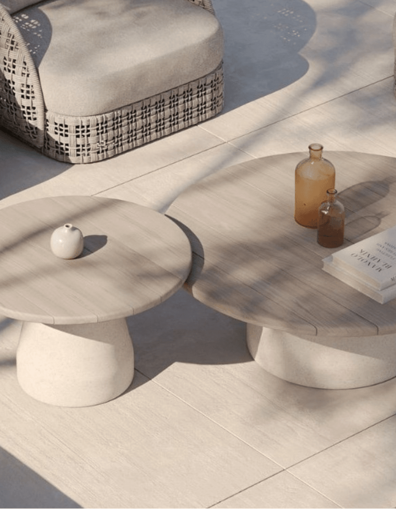 Two stone-like tables with decorative items on a tiled floor