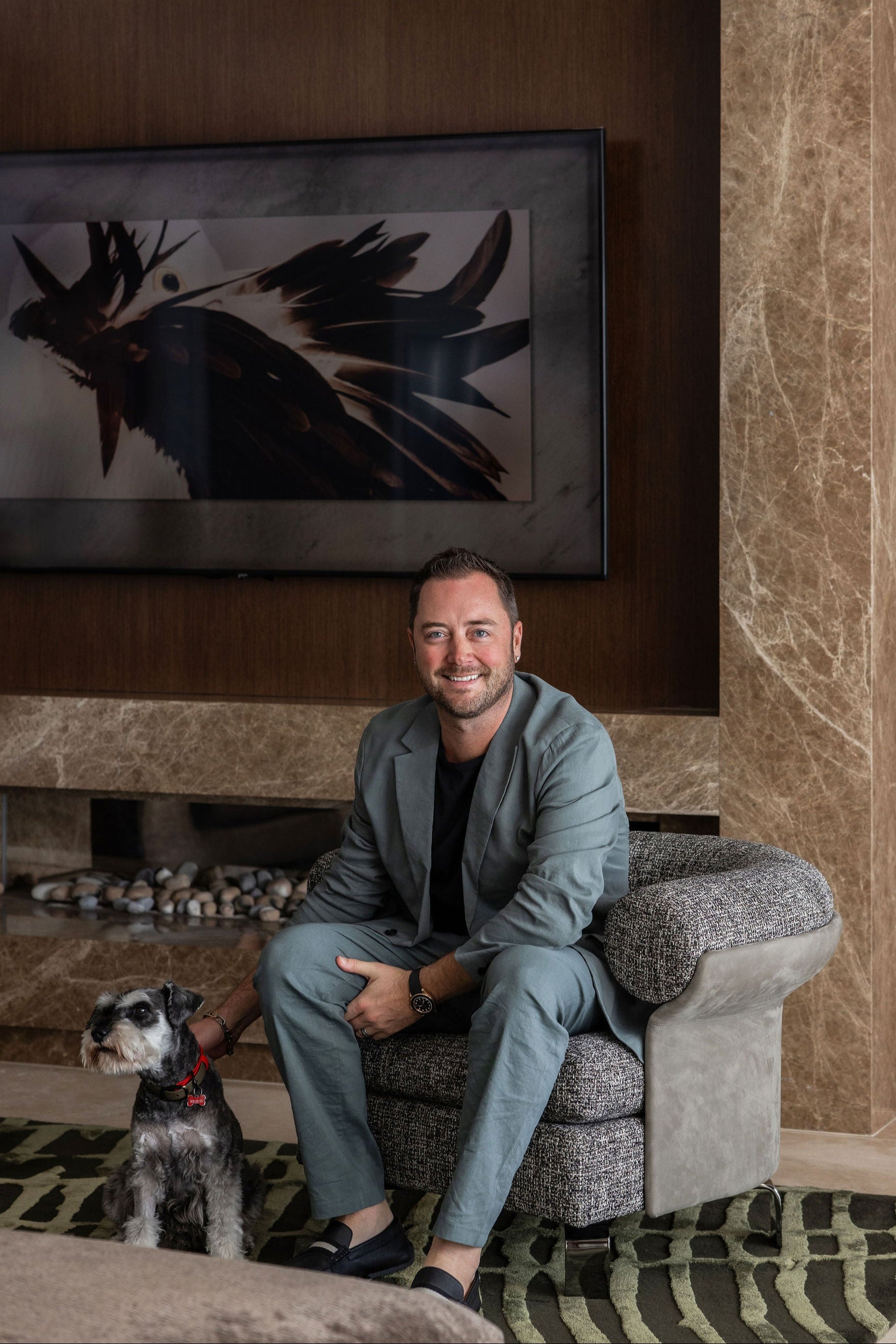 award winning Interior Designer Peter Kerr sitting with a mini schnauzer