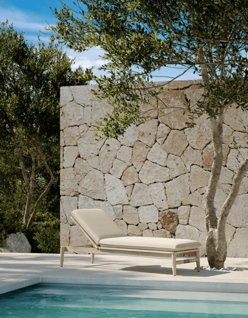 A teak sunlounge with sand material by a pool