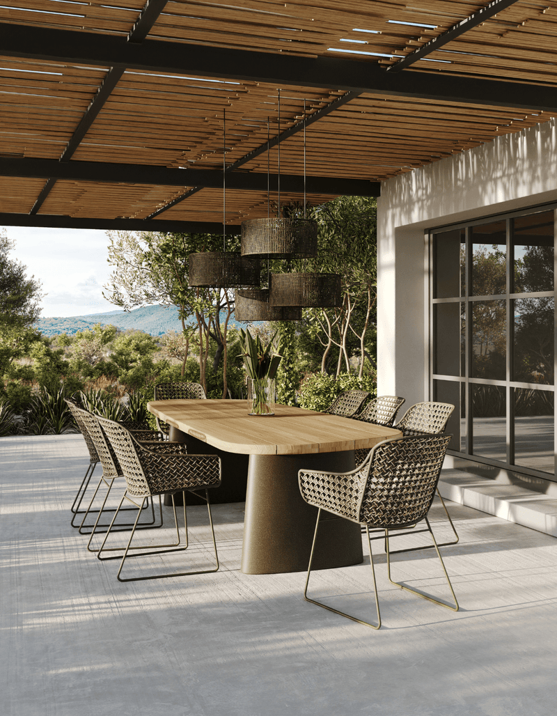 Outdoor dining area with wooden table and chairs under a wooden pergola.