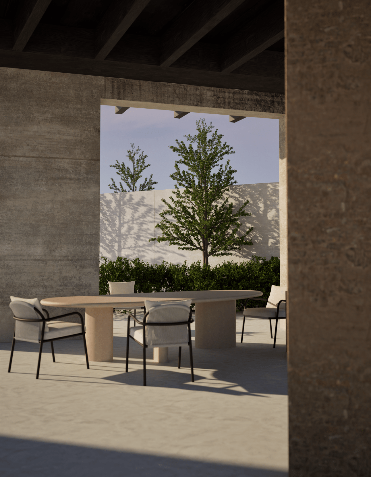 Modern outdoor dining set featuring a long oval stone table and six matching armchairs with light upholstery and black metal frames, situated under a concrete shelter with trees in the background.