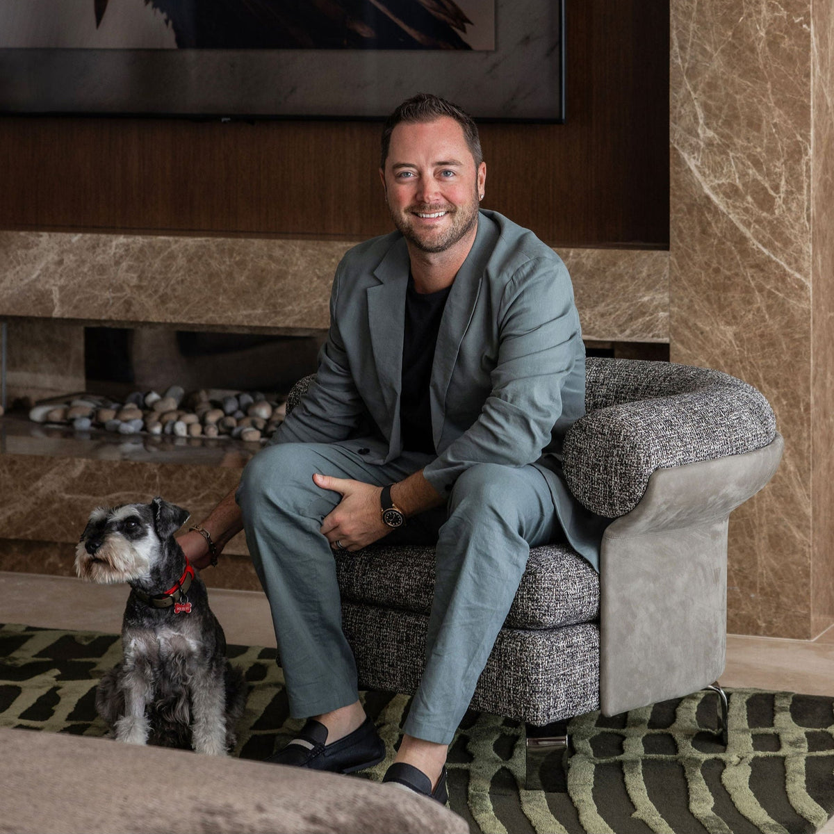 award winning Interior Designer Peter Kerr sitting with a mini schnauzer
